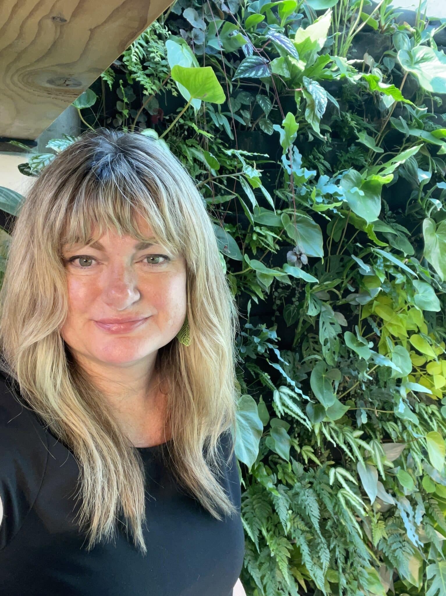 Michelle Ritter, founder and owner of Seattle Plant Company, photographed in front of a living wall.